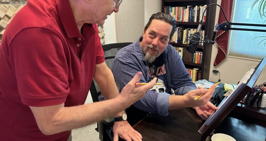 Voice acting coach reviewing a script with a student in a professional recording studio during voice-over training.